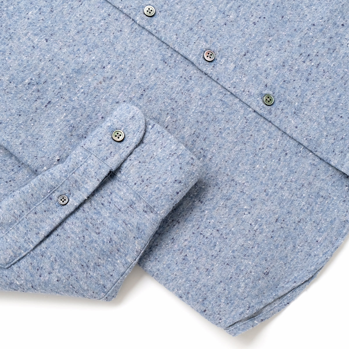 Light blue fleck flannel shirt sleeve cuff and buttoned pocket flap detail