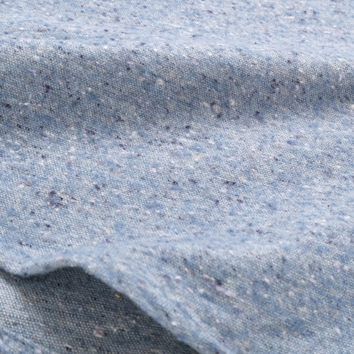 Light blue fleck flannel fabric texture close-up, breathable woven weave