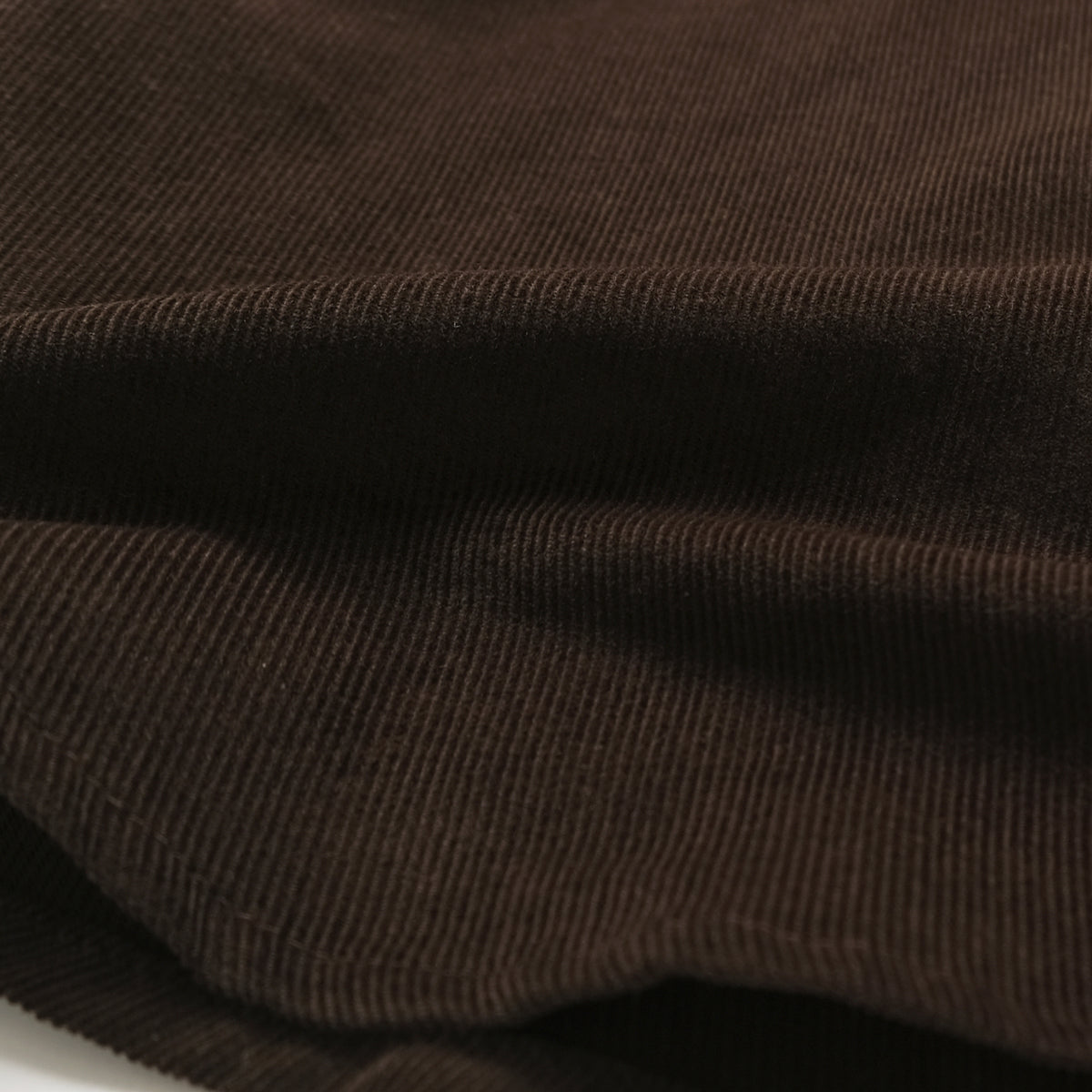 Brown corduroy fabric close-up with fine ridged texture