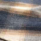 Blue and cream plaid flannel fabric close-up with textured weave
