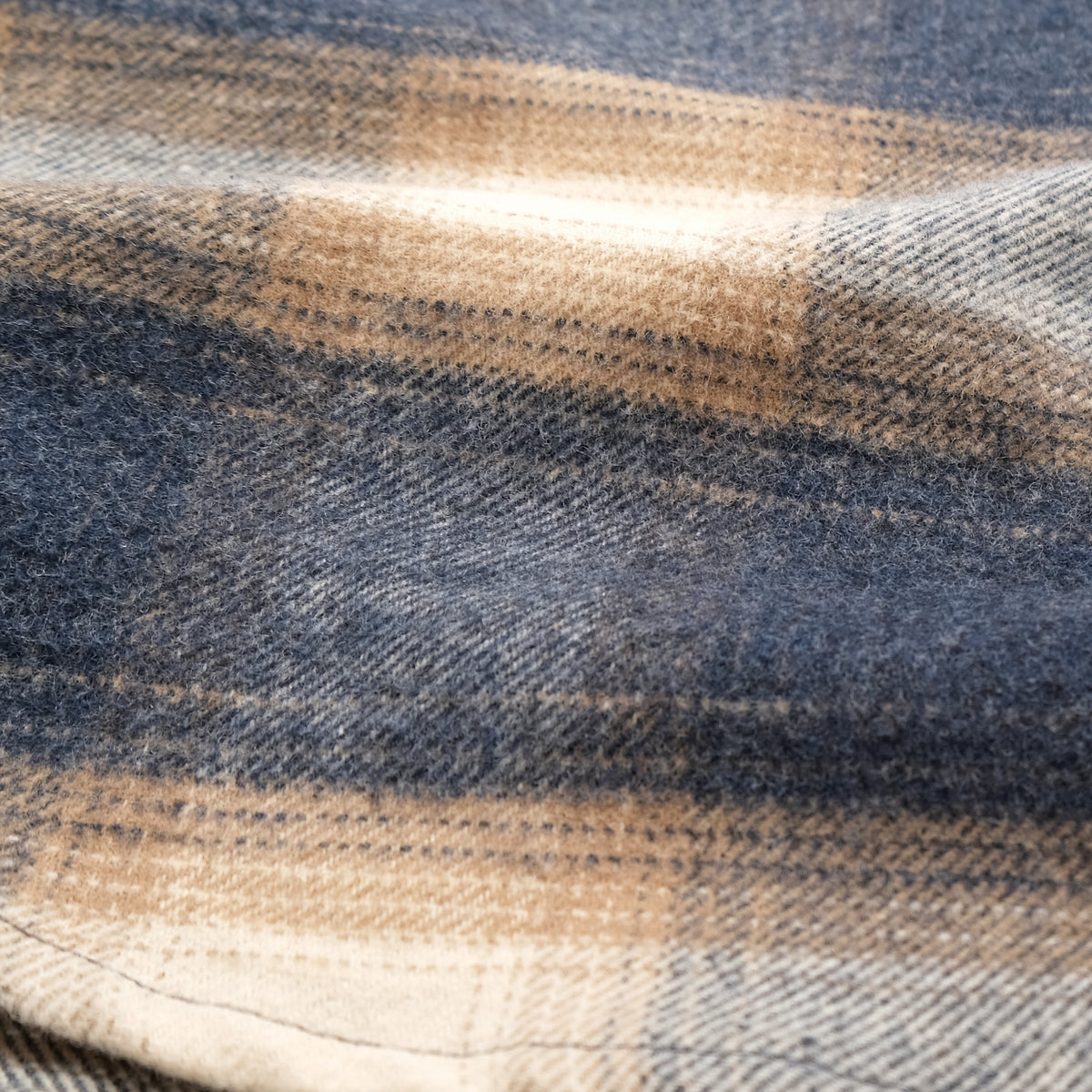 Blue and cream plaid flannel fabric close-up with textured weave