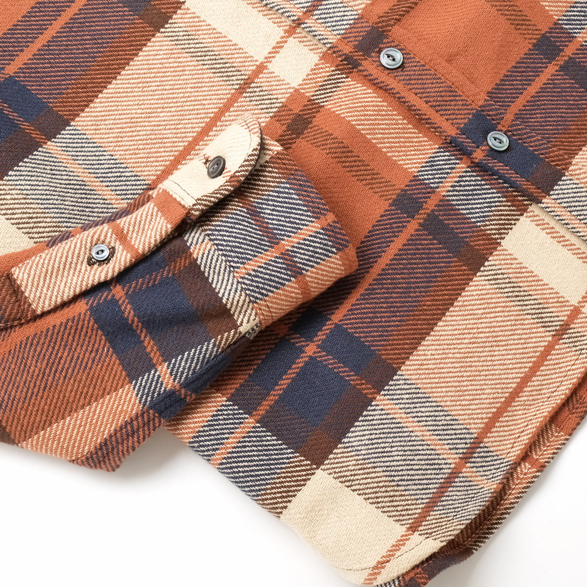 Plaid easy shirt sleeve cuff detail with buttoned tab, rust, navy, and cream