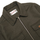 Olive wool field jacket detail with front zipper and button flap pockets