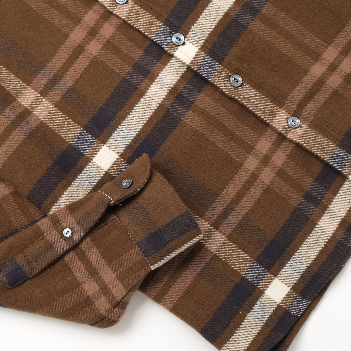 Olive-brown plaid shirt detail with chest snap buttons and flap pockets