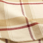 Ecru plaid flannel fabric close-up with woven texture and red/brown checks