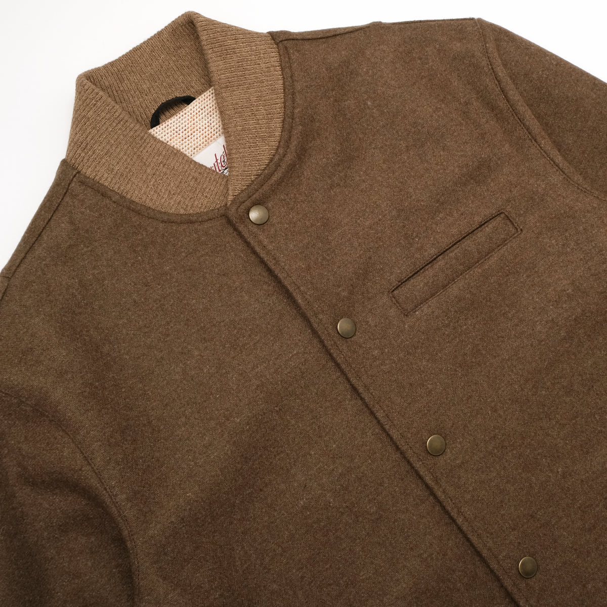 Brown stadium jacket with snap placket, chest pocket, and ribbed collar