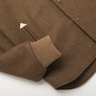 Brown stadium jacket sleeve cuff and hem detail with snap front