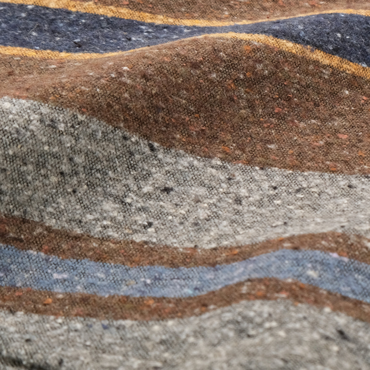 Close-up of striped shirt fabric texture in brown, gray, and blue