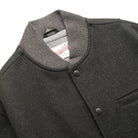 Charcoal stadium jacket close-up with ribbed stand collar and snap button placket