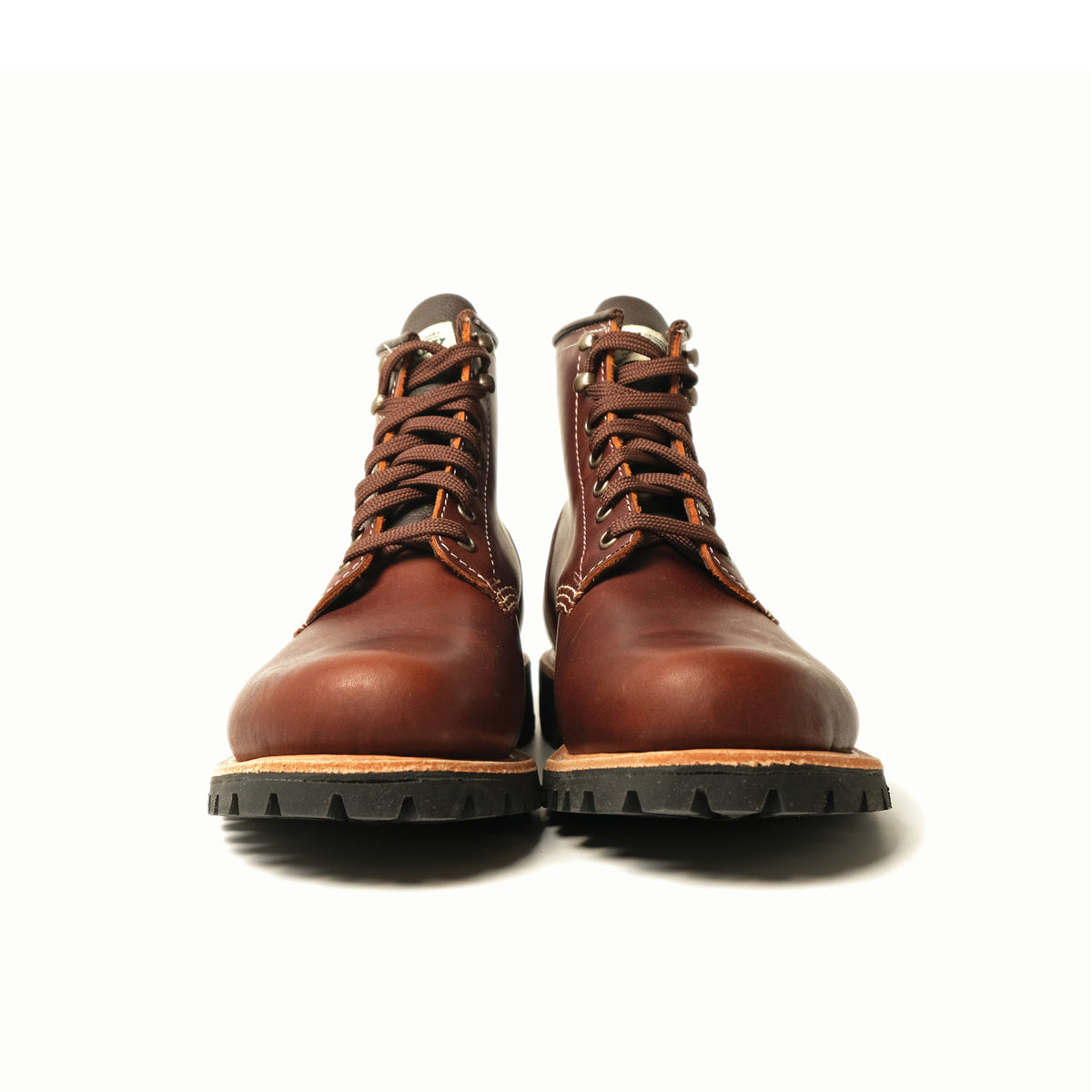 Pair of brown lace-up hiking boots showing heels and rugged tread soles.