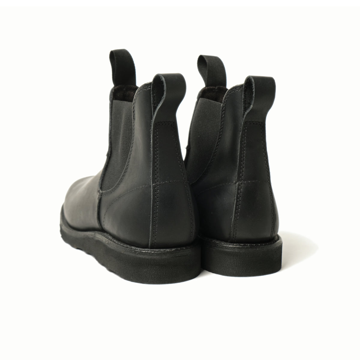 Black Chelsea boots rear view, elastic gore panels and low-profile rubber sole