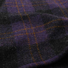 Close-up of wool plaid fabric with purple, blue, and yellow threads