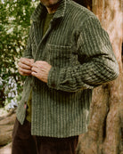Olive corduroy club shirt on model, long sleeves, buttoned front, chest pocket