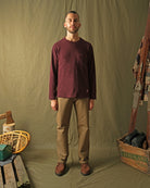 Maroon long-sleeve T-shirt with chest pocket and crew neck, worn with trousers.