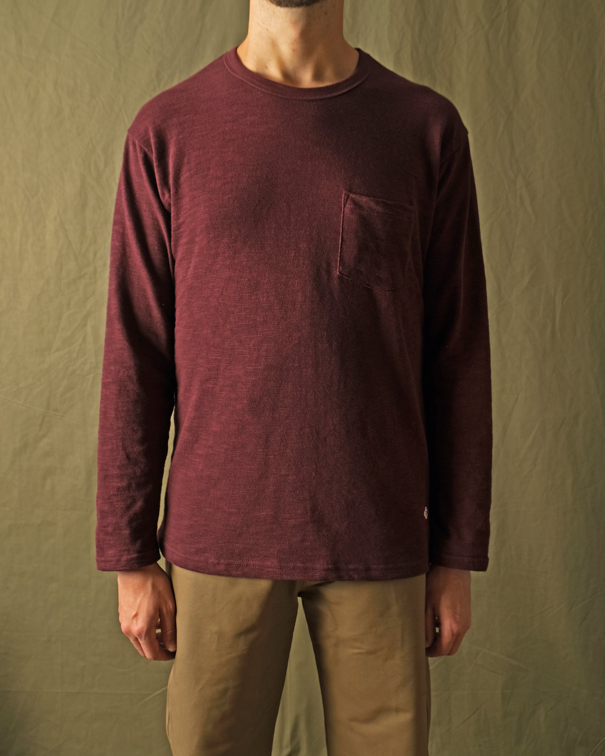 Maroon long-sleeve T-shirt with chest pocket and crew neck, textured slub knit.