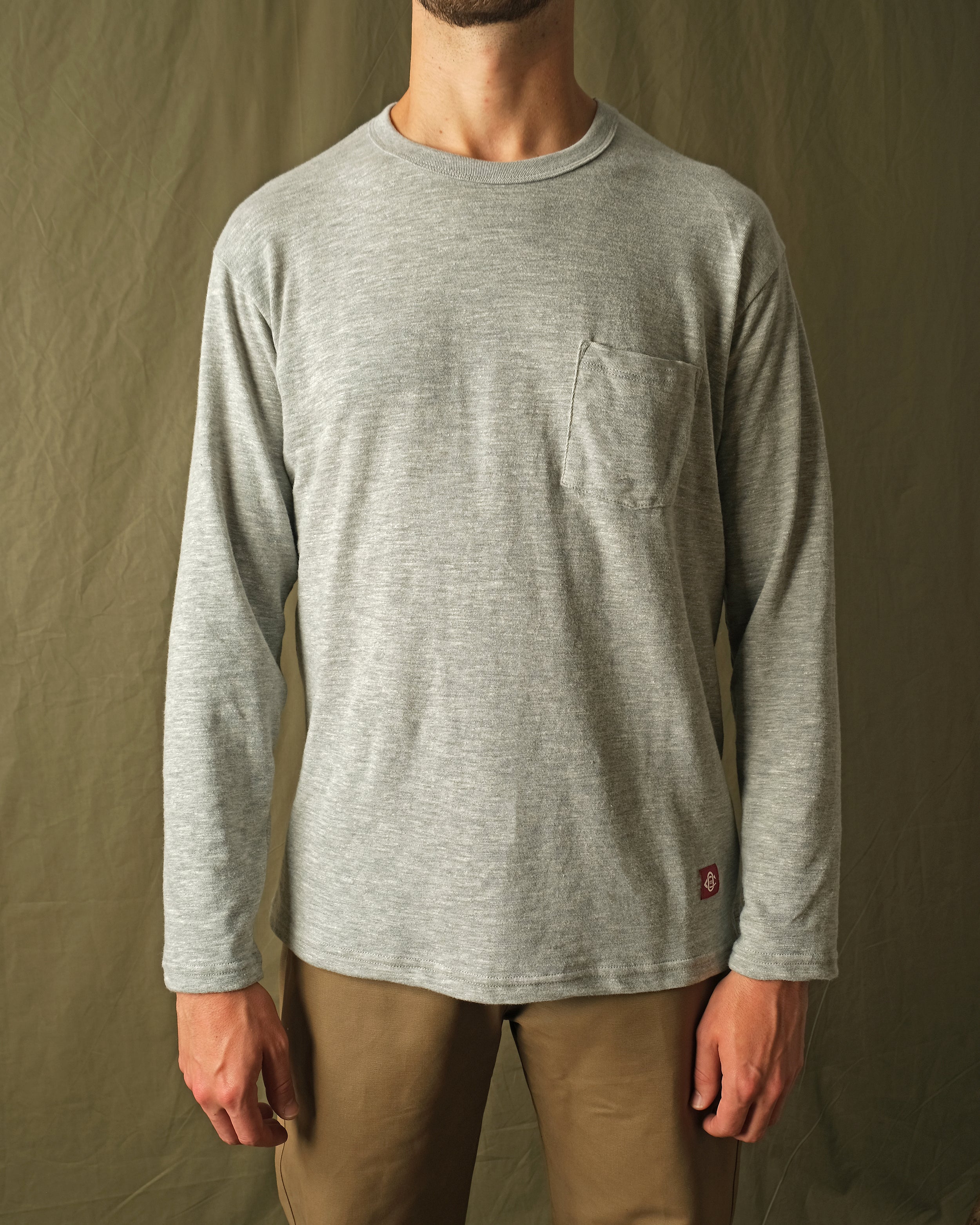 Heather gray long-sleeve t-shirt with crew neck and chest pocket on model
