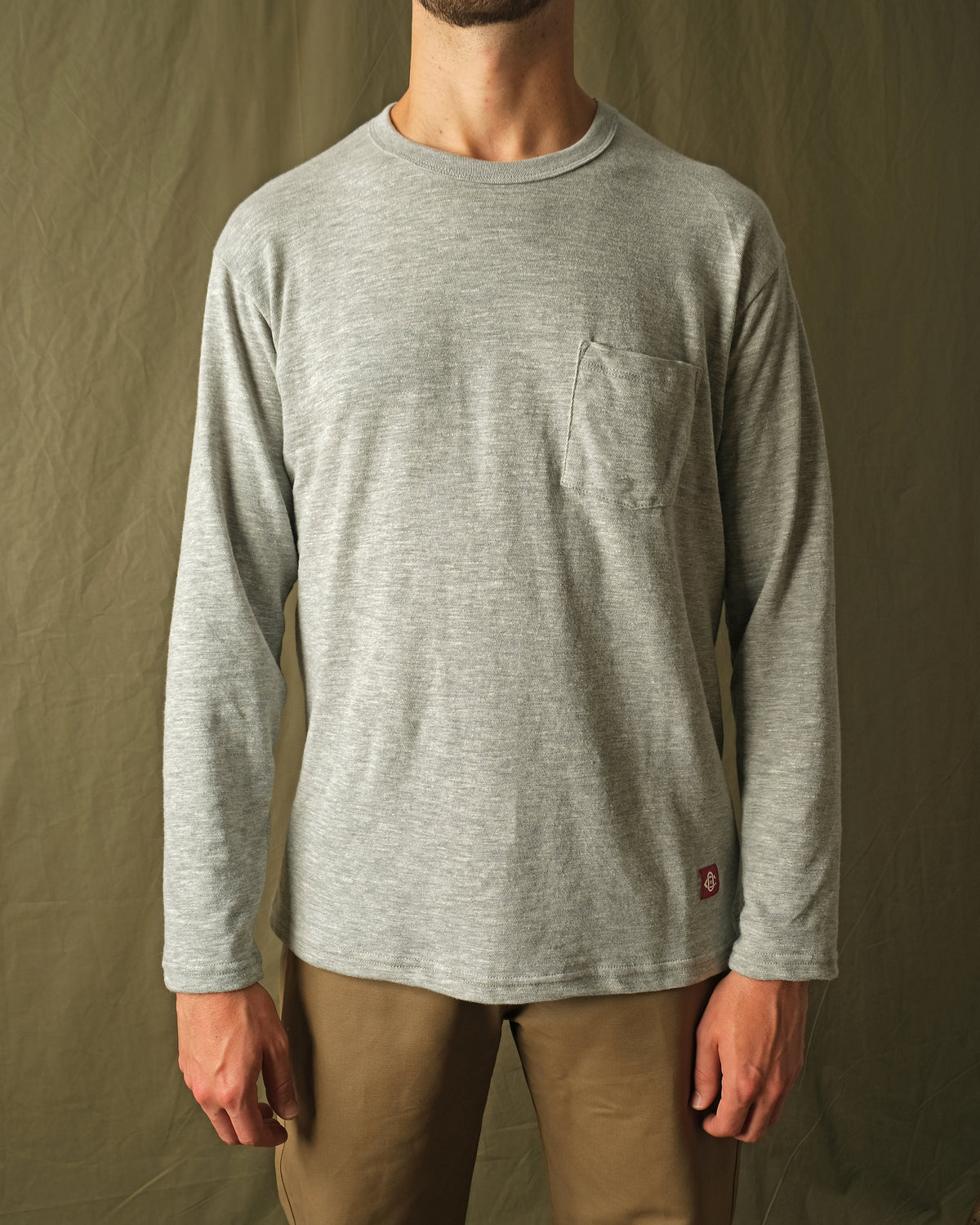 Heather gray long-sleeve t-shirt with crew neck and chest pocket on model