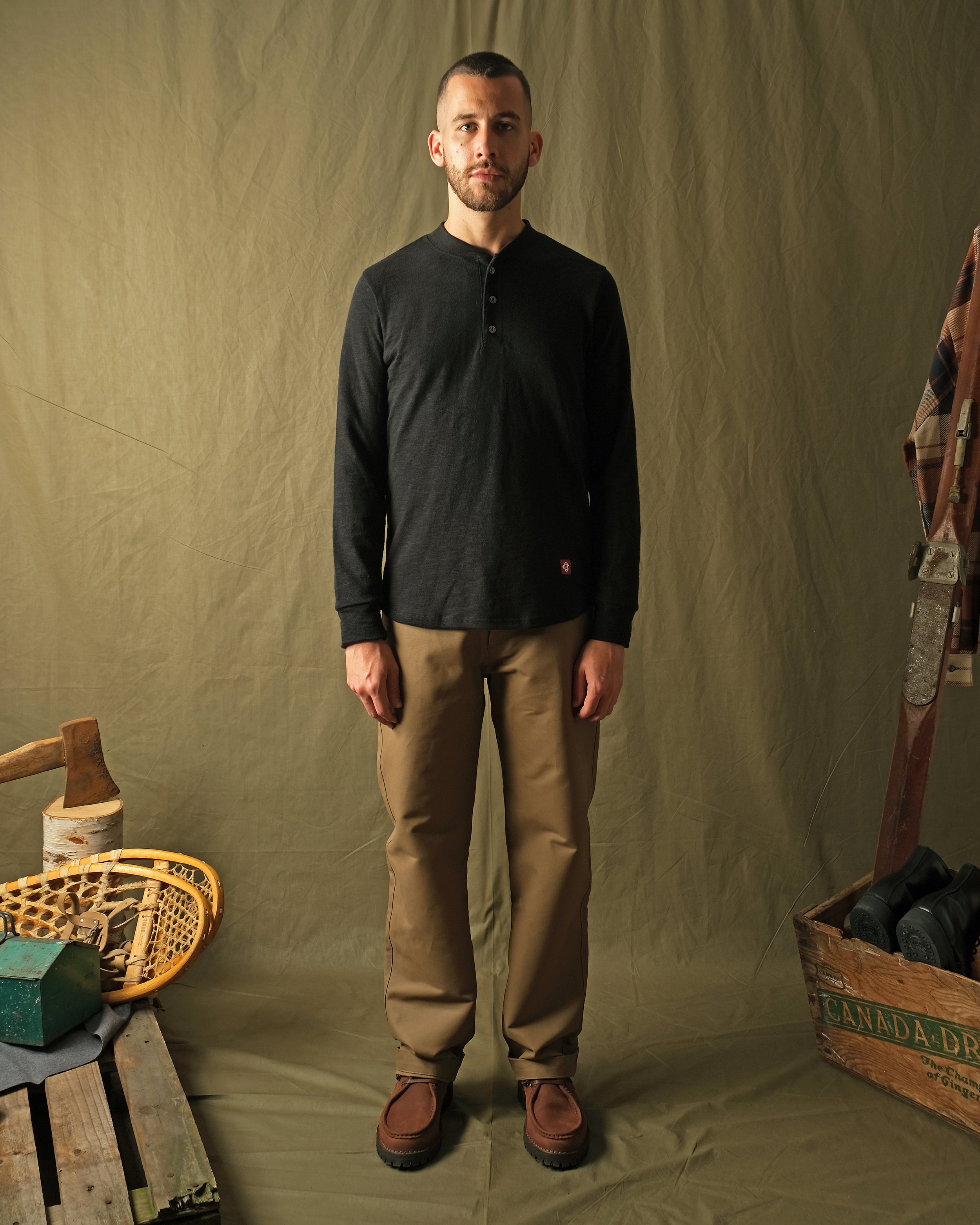 Black slub long-sleeve henley shirt worn with tan pants; three-button neckline