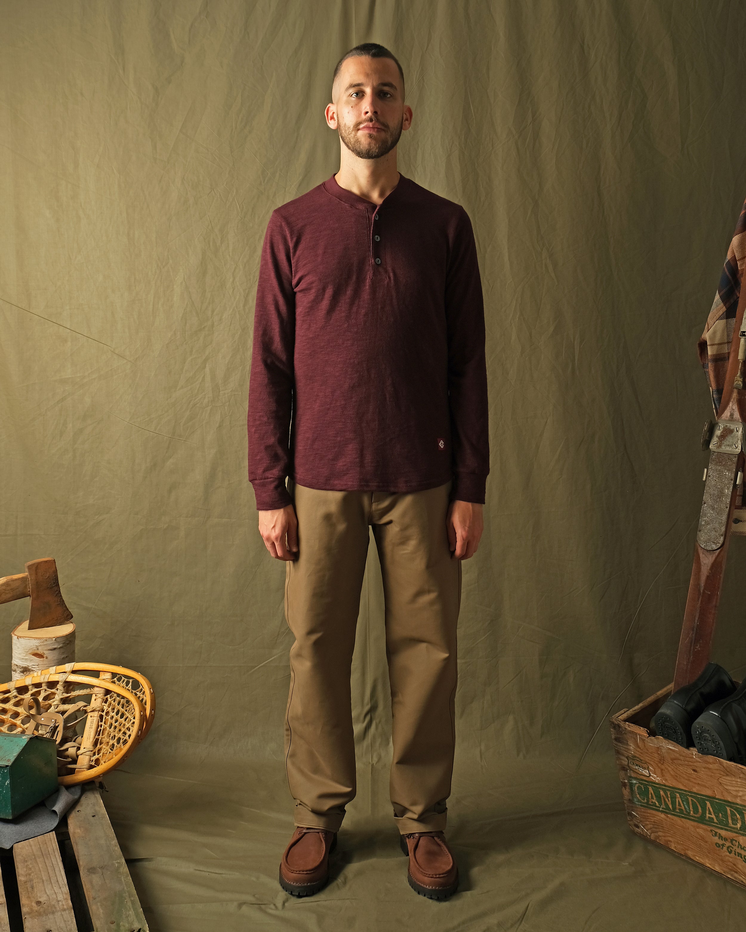 Maroon long-sleeve henley shirt on model, buttoned neckline