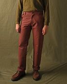 Brick red engineer pants on model, straight silhouette with belt loops and cuffed hem