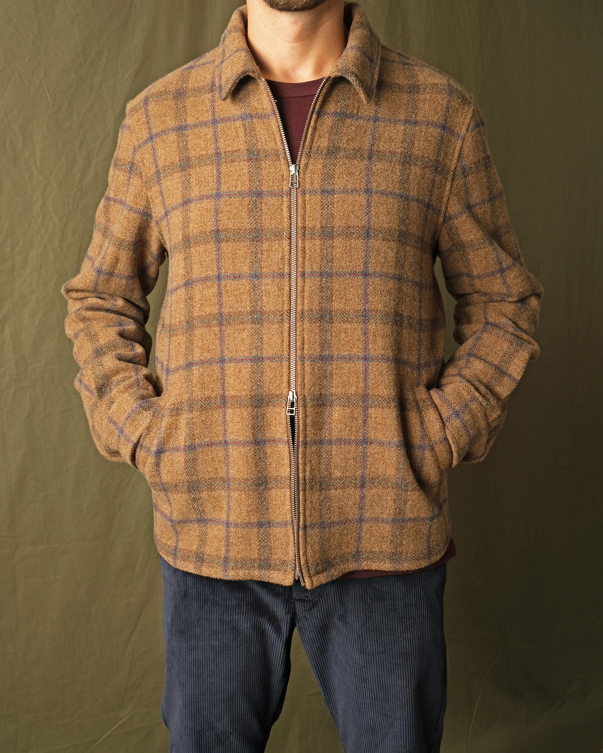 Wool plaid zip overshirt on model torso, stand collar, long sleeves, metal zipper
