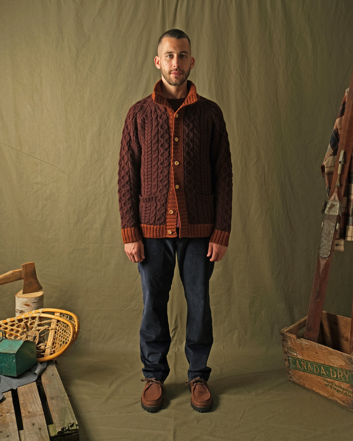 Men's dark maroon cable-knit mock neck cardigan with orange front placket and pockets