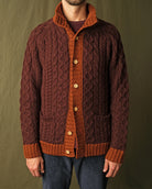 Dark maroon cable-knit mock neck cardigan with orange buttons, placket, and patch pockets