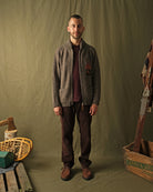 Brown zip cardigan worn by a man with left-chest campfire embroidery