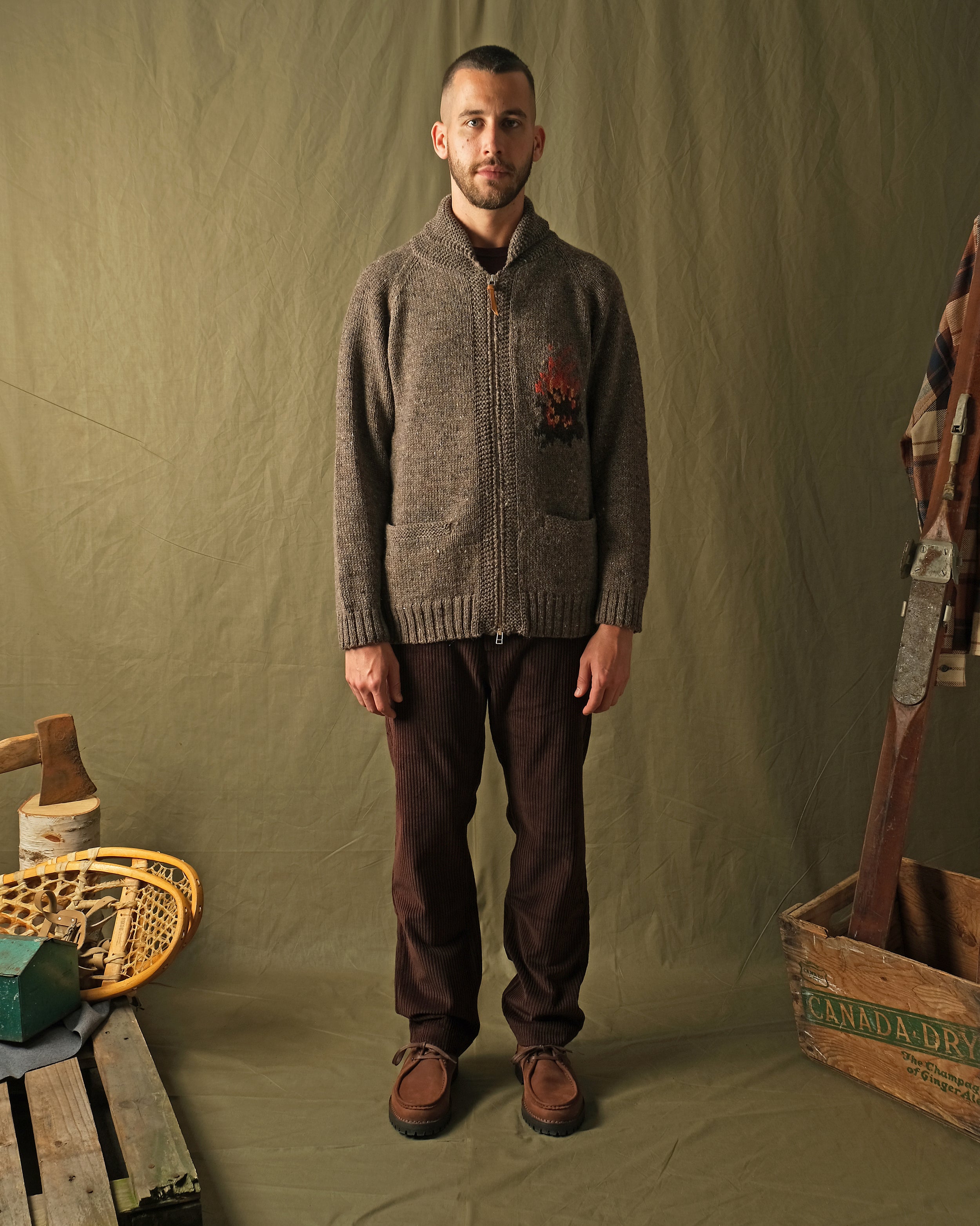 Gray knit zip cardigan with campfire motif on chest, ribbed cuffs and hem.