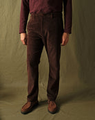 Dark brown corduroy camp pants with wide leg and cuffed hem on model.
