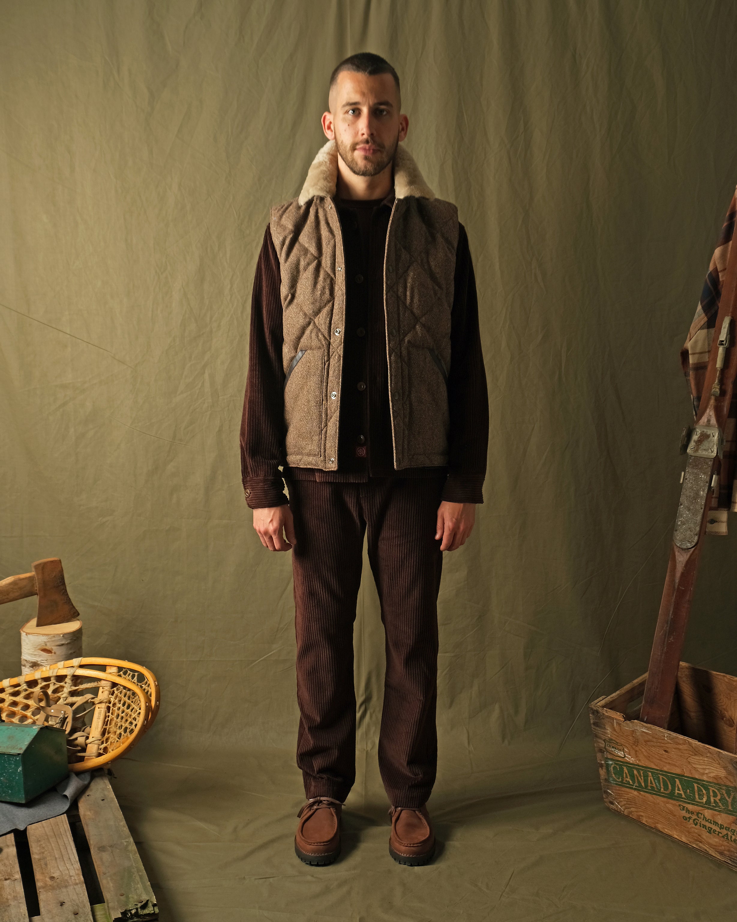 Brown diamond-quilted down vest with tan sherpa collar on model, front view