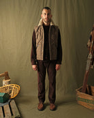 Brown diamond-quilted down vest with tan sherpa collar on model, front view