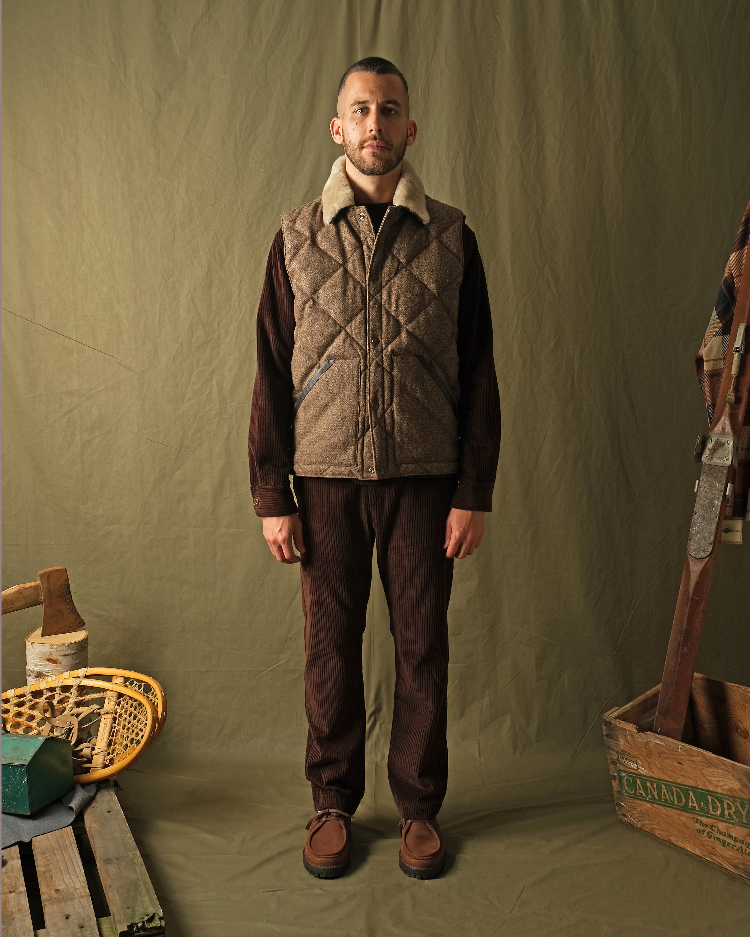 Brown diamond-quilted down vest with tan sherpa collar on model, full front