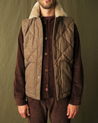 Brown quilted down vest with tan sherpa collar and button front with chest pockets