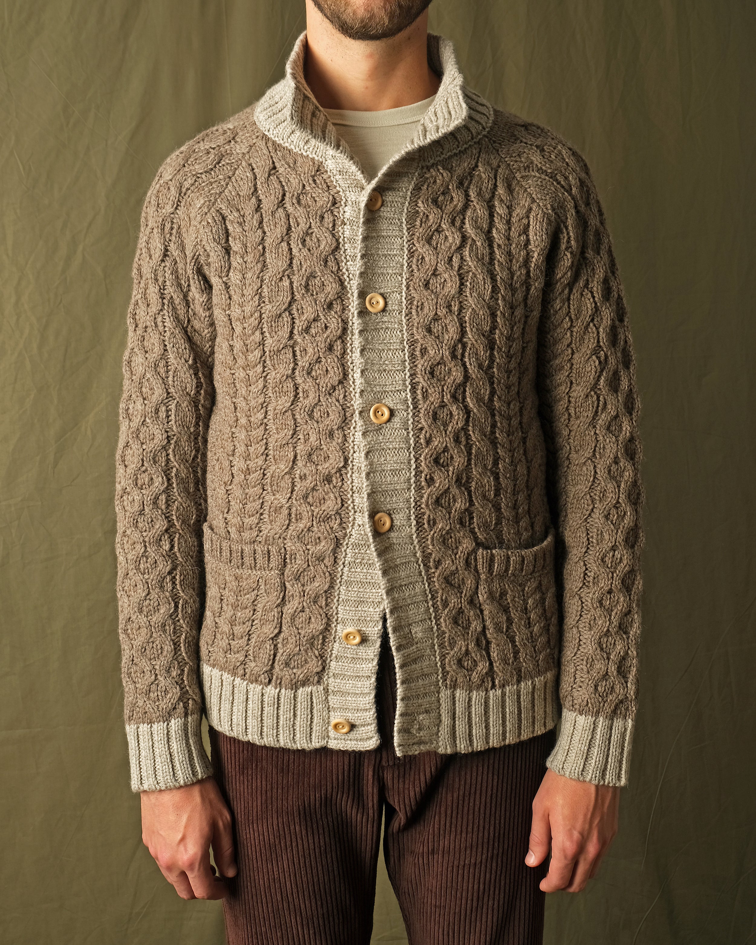 Men's cable knit cardigan with cream yoke, mock neck, button-front, and pocket