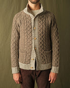 Men's cable knit cardigan with cream yoke, mock neck, button-front, and pocket