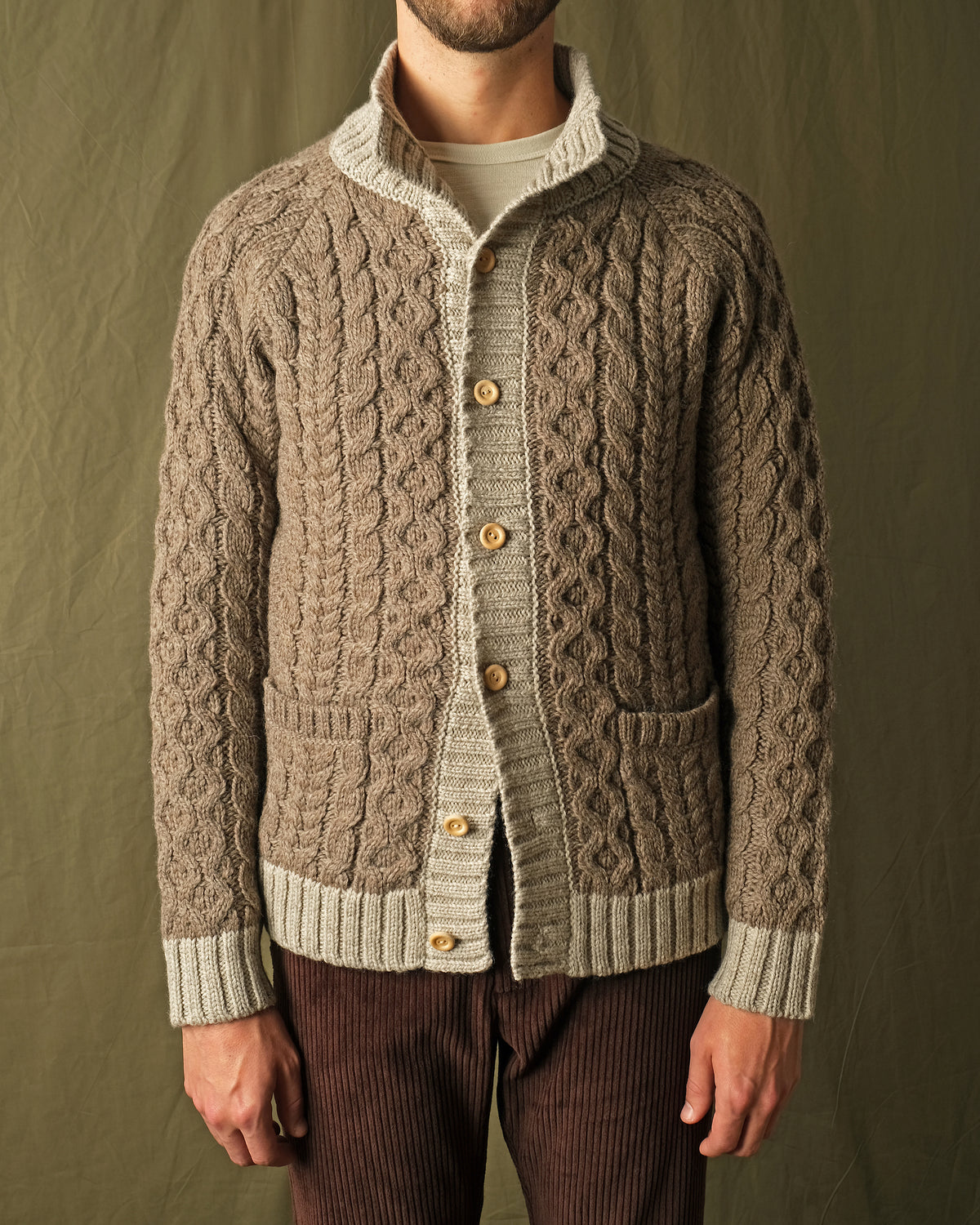 Men's cable knit cardigan with cream yoke, mock neck, button-front, and pocket