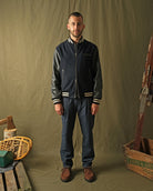 Navy bomber jacket with striped ribbed collar, cuffs, and zipper front on model
