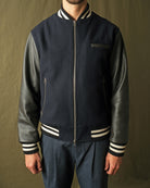 Navy bomber jacket with striped ribbed collar and cuffs; front zipper and chest pocket