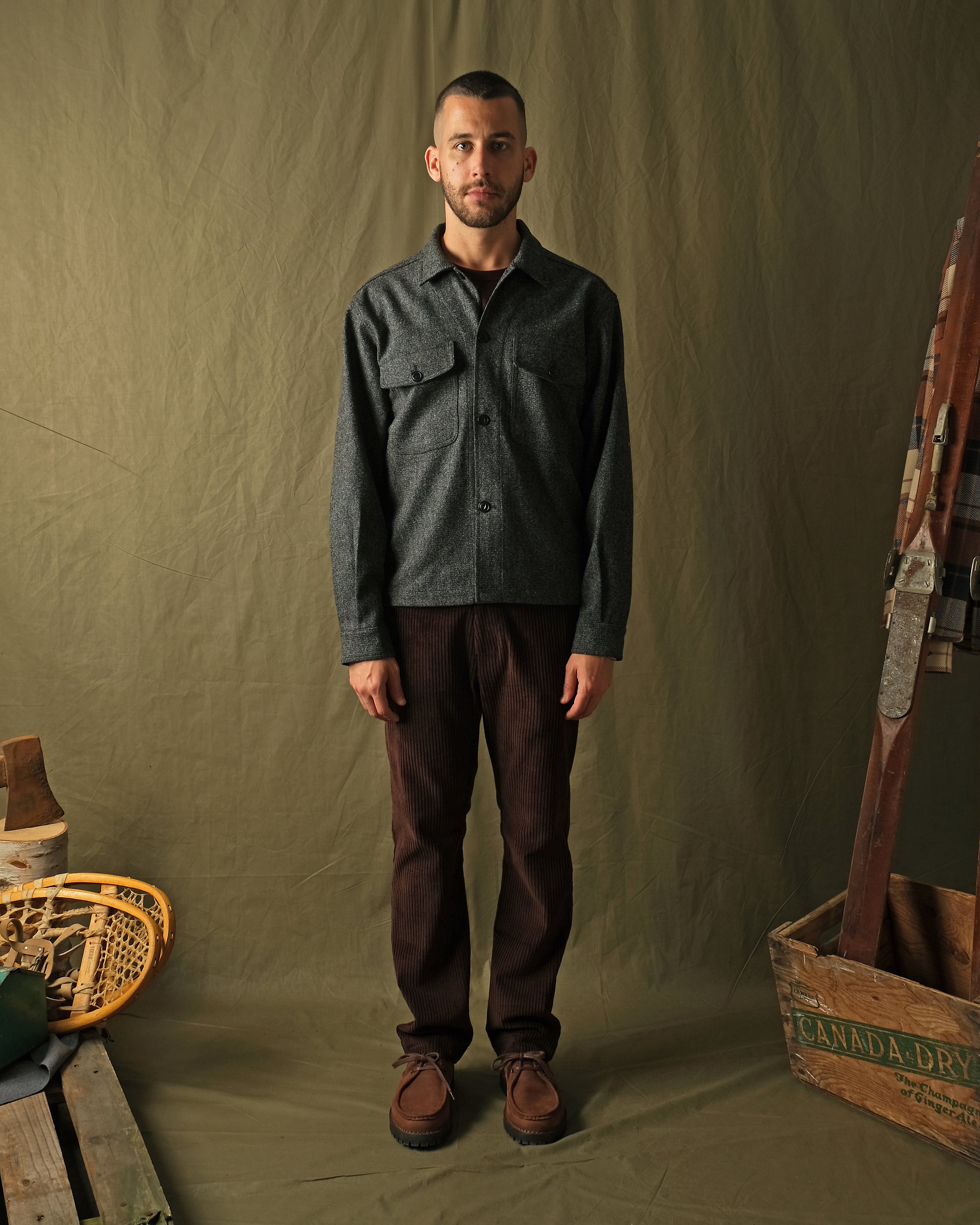 Dark charcoal speckled wool camp shirt on model, long sleeves and flap chest pockets.