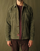 Olive jumbo corduroy club shirt on model, long sleeves, button-front, chest pocket