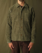 Olive jumbo corduroy club shirt on model, spread collar, brown button placket, long sleeves