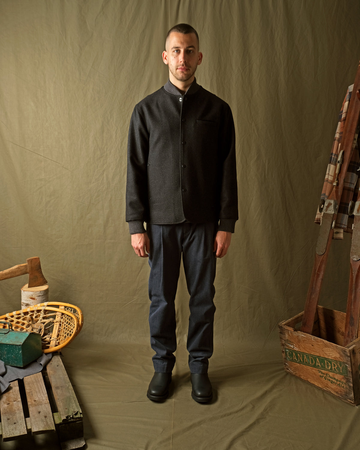 Charcoal stadium jacket worn by model, snap-up front with ribbed hem and cuffs