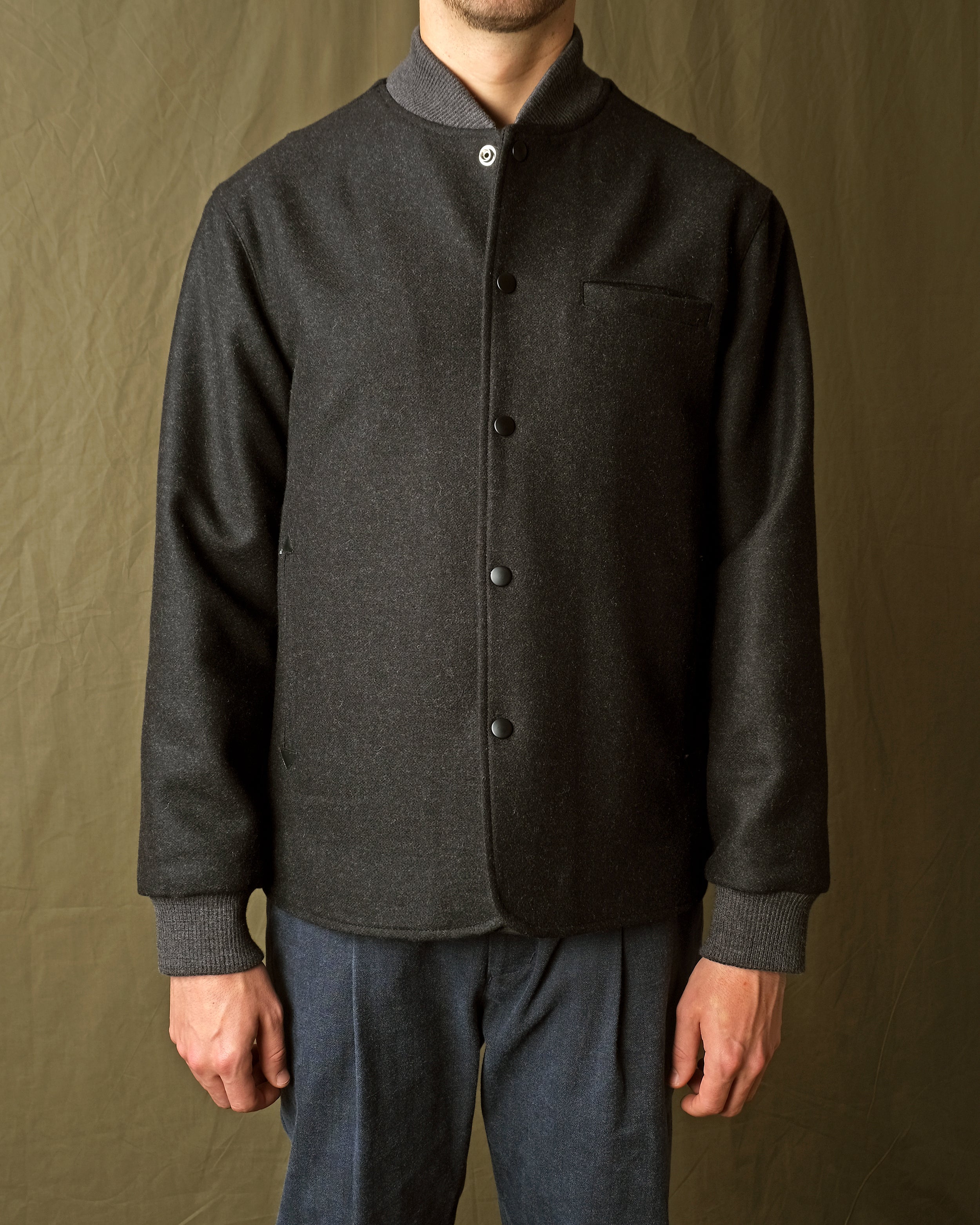 Charcoal stadium jacket close-up with stand collar and snap buttons