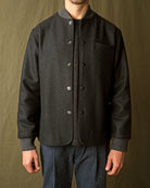 Charcoal stadium jacket front close-up with snap placket and ribbed cuffs