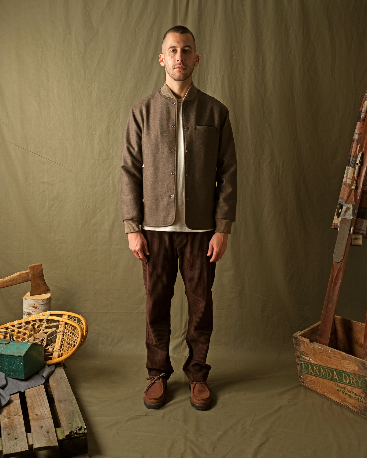 Mens brown stadium jacket with snap button front, stand collar, and chest pocket