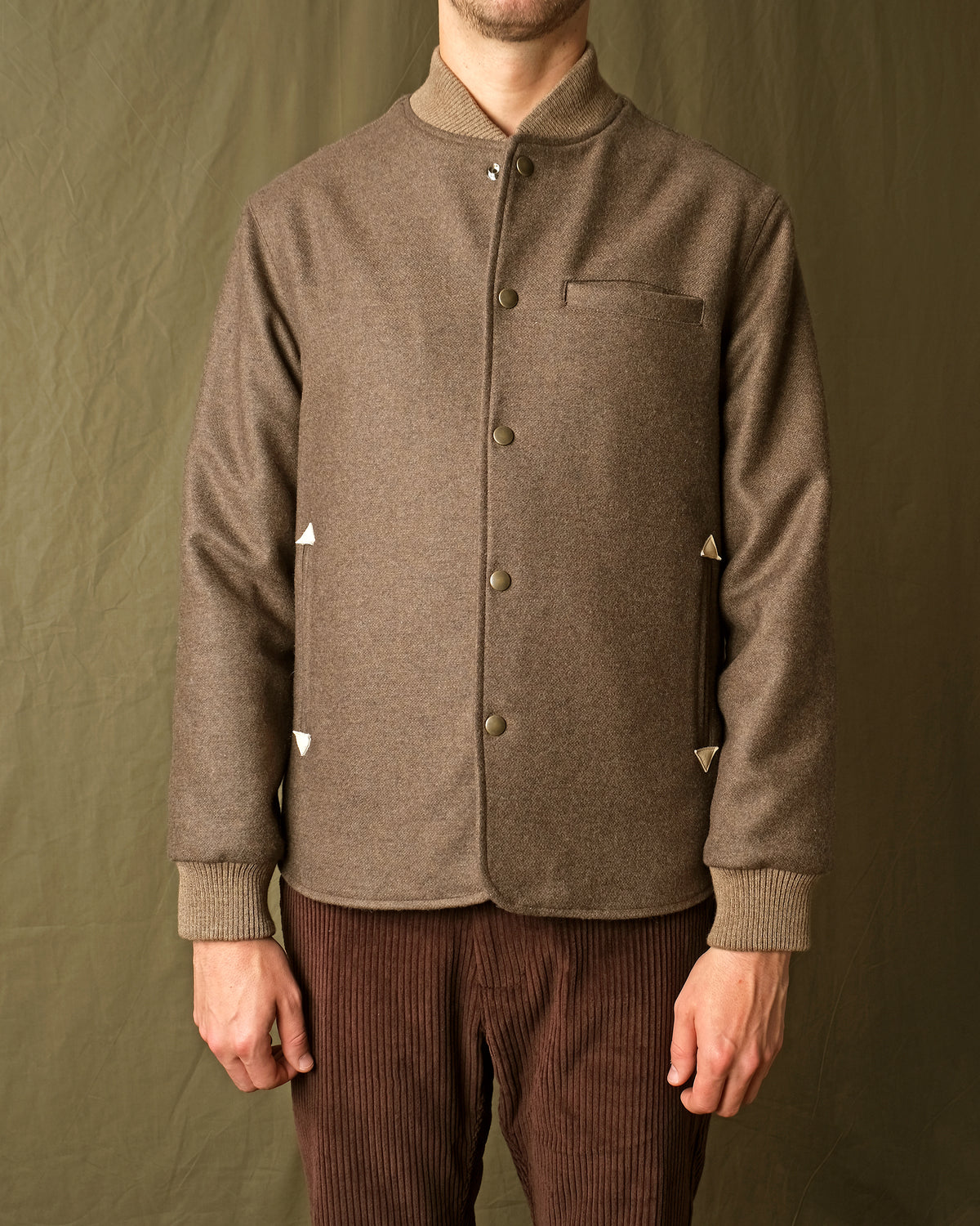 Brown stadium jacket with snap button front, stand collar, chest pocket, ribbed cuffs