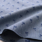 Light blue fabric with navy palm print, close-up of sleeve hem